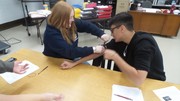 Stop the Bleed Training - Students using gauze with fake blood being pushed through to simulate the process.